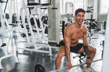 Beden eğitiminde güçlü kaslı adam pazularda egzersiz yapıyor. Ağırlık antrenmanı konsepti.