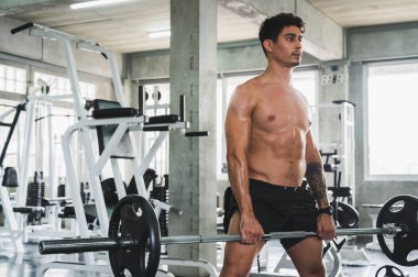 Beden eğitiminde güçlü kaslı adam pazularda egzersiz yapıyor. Ağırlık antrenmanı konsepti.