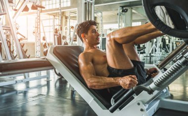 Beden eğitiminde güçlü kaslı adam pazularda egzersiz yapıyor. Ağırlık antrenmanı konsepti.