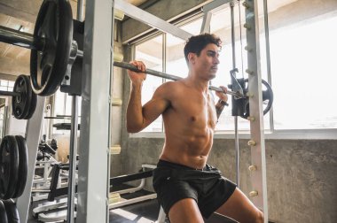 Beden eğitiminde güçlü kaslı adam pazularda egzersiz yapıyor. Ağırlık antrenmanı konsepti.