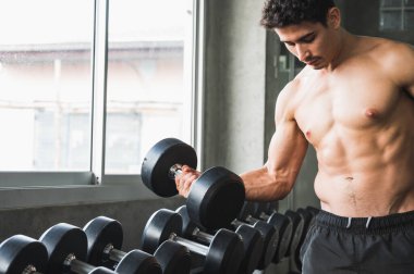 Beden eğitiminde güçlü kaslı adam pazularda egzersiz yapıyor. Ağırlık antrenmanı konsepti.