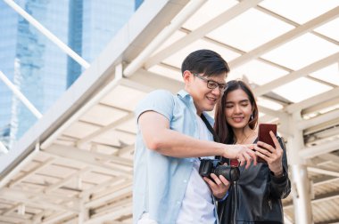 Gezgin bir aşık turistik yerleri bulmak için akıllı telefon kullanıyor. Seyahat, alışveriş ve tatil konsepti.