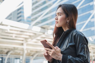 Genç Asyalı güzel kadınlar akıllı telefon kullanıyor. .