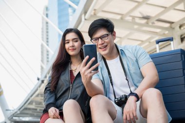 Gezgin bir aşık turistik yerleri bulmak için akıllı telefon kullanıyor. Seyahat, alışveriş ve tatil konsepti.