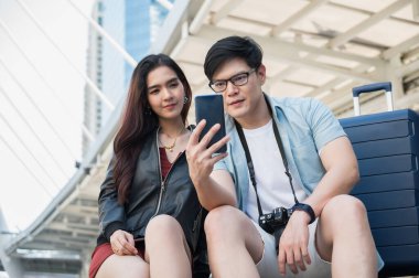 Gezgin bir aşık turistik yerleri bulmak için akıllı telefon kullanıyor. Seyahat, alışveriş ve tatil konsepti.