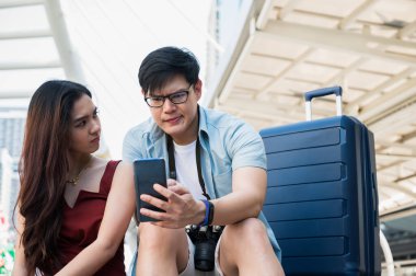 Gezgin bir aşık turistik yerleri bulmak için akıllı telefon kullanıyor. Seyahat, alışveriş ve tatil konsepti.