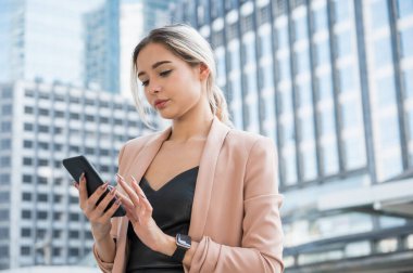 Ofiste telefonu kullanan gülümseyen genç bir iş kadını portresi..