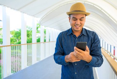 Genç Asyalı adam akıllı telefon kullanıyor..