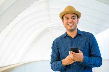 Genç Asyalı adam akıllı telefon kullanıyor..