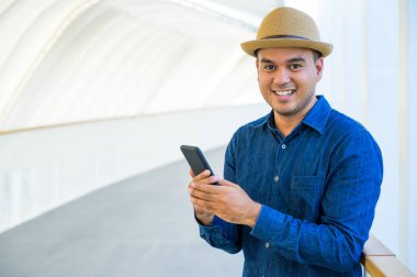 Genç Asyalı adam akıllı telefon kullanıyor..