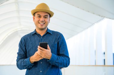 Genç Asyalı adam akıllı telefon kullanıyor..