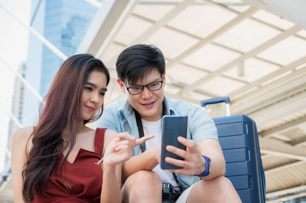 Gezgin bir aşık turistik yerleri bulmak için akıllı telefon kullanıyor. Seyahat, alışveriş ve tatil konsepti.