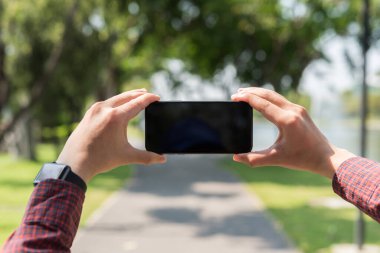Erkek elini kapat ve fotoğraf çekmek için akıllı telefon tut..