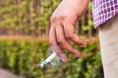 Sigara içen genç adam. Elinde sigara tutan adam..