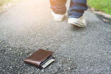 Cüzdanı yerde. Adam cüzdanını kaybetmiş.