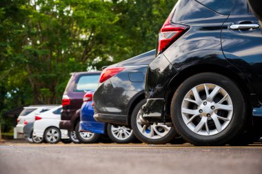 Birçok araba büyük bir otoparka park edilmiştir. Uzun bir sıra halinde dizilmişti güneşin battığı zamandı