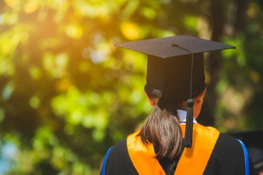 Mezunların arka görünüşü üniversitedeki mezuniyet törenine katılıyor. Üniversite teması konseptinde eğitim mezuniyeti.