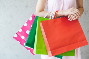 Alışveriş torbalarını tutan kadına yakın durun..