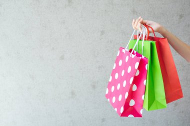 Alışveriş torbalarını tutan kadına yakın durun..