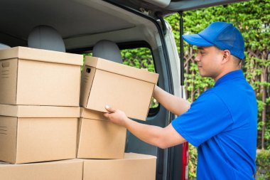 Mavi teslimatçı kamyondaki karton kutuyu aldı.