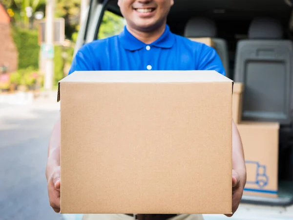 Blue Delivery man holding parcel cardboard box.