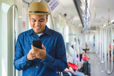 Gökyüzü treninde akıllı telefon kullanan Asyalı bir adam.