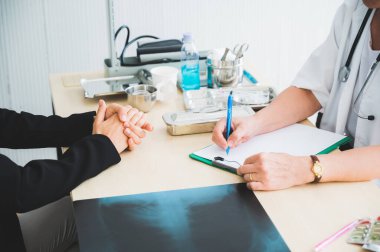 Kıdemli bayan doktor hastayla buluş ve semptom sorunu hakkında görüş ve notlar al. Tıp konseptinde sağlık ve müşteri hizmetleri.