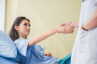 Bayan doktor hastayla tanış ve tokalaş.