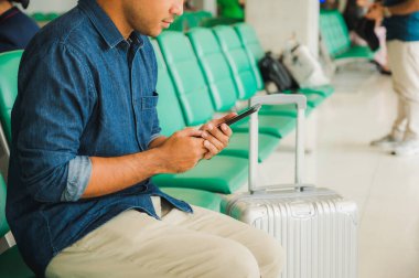 Trolley çantalı gezginler iletişim kurmak için akıllı telefon kullanıyor..