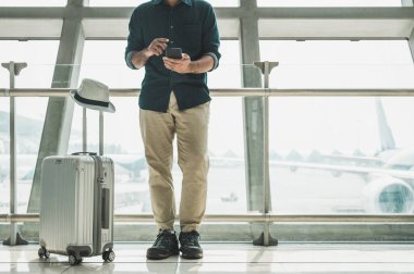 Turistler havaalanındaki akıllı telefonlarından tur programlarını kontrol ediyorlar..