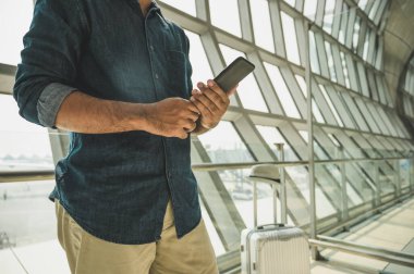 Turistler havaalanındaki akıllı telefonlarından tur programlarını kontrol ediyorlar..