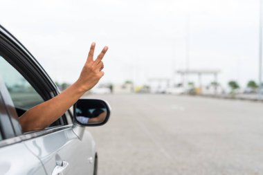 Arabayı süren adam iki parmağını gösteriyor.