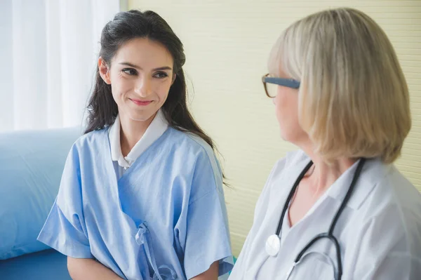 Arts Zorgt Voor Vrouwelijke Patiënt Terwijl Zit Het Bed — Stockfoto