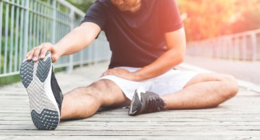 Genç fitness koşucusu kopyalama alanı ile çalıştırmadan önce geriniyor.