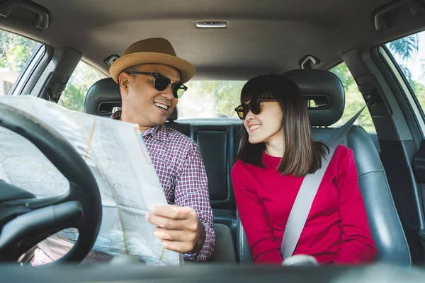 Couple asian man and woman sitting in car looking map. Enjoying travel concept.