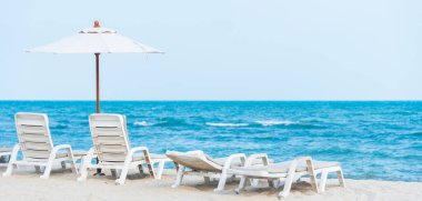 Tropikal plajda beyaz plaj sandalyesi