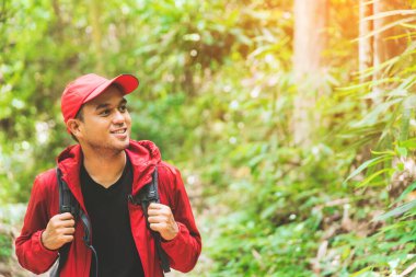 Genç Asyalı gezgin ormanda ve dağda yürüyüş yapıyor. Doğada yürümenin tadını çıkarıyor..