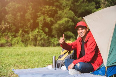 Doğada çadırı olan Asyalı genç bir gezgin. Sırt çantası, Rahatlatıcı, Tatil, Etkinlikler, Kopya alanı ile Yürüyüş kavramı.