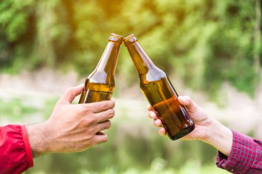 Erkek ve kadınlar bira şişesiyle kutlama yapıyorlar..