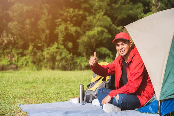Young asian traveler man camping with tent in nature. Backpacker, Relaxing, Holiday, Activities, Hiking concept with copy space.