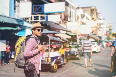 Genç Asyalı gezgin adam Bangkok 'ta Khaosan Yolu' nda yürüyor.