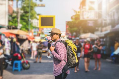 Genç Asyalı gezgin adam Bangkok 'ta Khaosan Yolu' nda yürüyor.