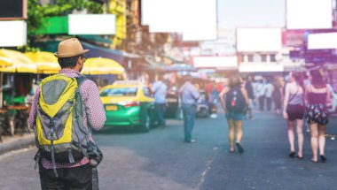 Genç Asyalı gezgin adam Bangkok 'ta Khaosan Yolu' nda yürüyor.