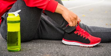 Yaklaş. Koşan adam ayakkabı bağcıklarını bağlıyor.