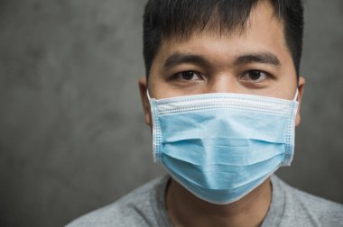 Korunaklı yüz maskesi takan Asyalı genç adamı Coronavirus 'a karşı kapatın..