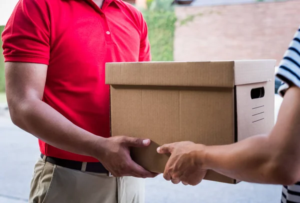 Delivery man in red Uniform Giving parcel cardboard box
