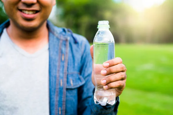 Young handsome asian man drinking water