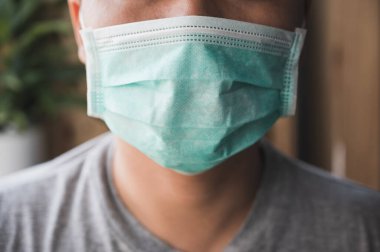 Korunaklı yüz maskesi takan Asyalı genç adamı Coronavirus 'a karşı kapatın..