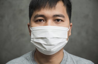Korunaklı yüz maskesi takan Asyalı genç adamı Coronavirus 'a karşı kapatın..