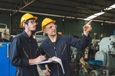 Endüstriyel işçiler büyük sanayi tesislerinde pek çok cihazlı projeler üzerinde çalışıyorlar..